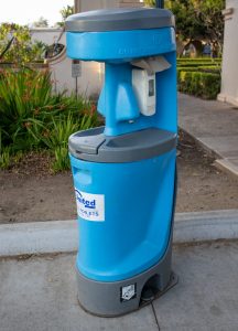 Portable hand wash station on concrete path