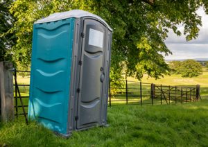 porta potty in a grassy field